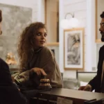 Tamu berinteraksi dengan resepsionis di meja depan hotel mewah